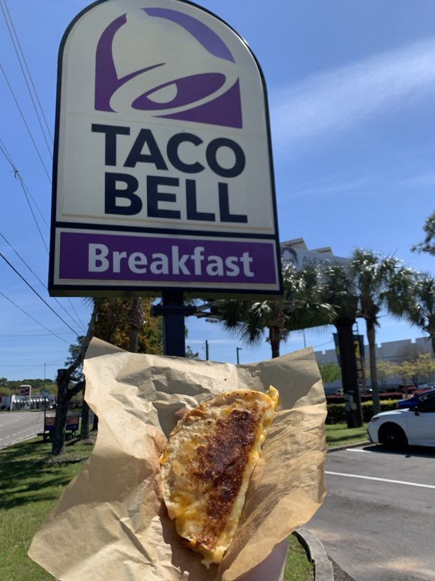 taco in front of Taco Bell sign